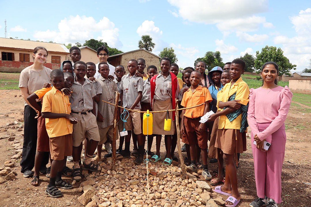 A group of students in Ghana showing a new tippy tap